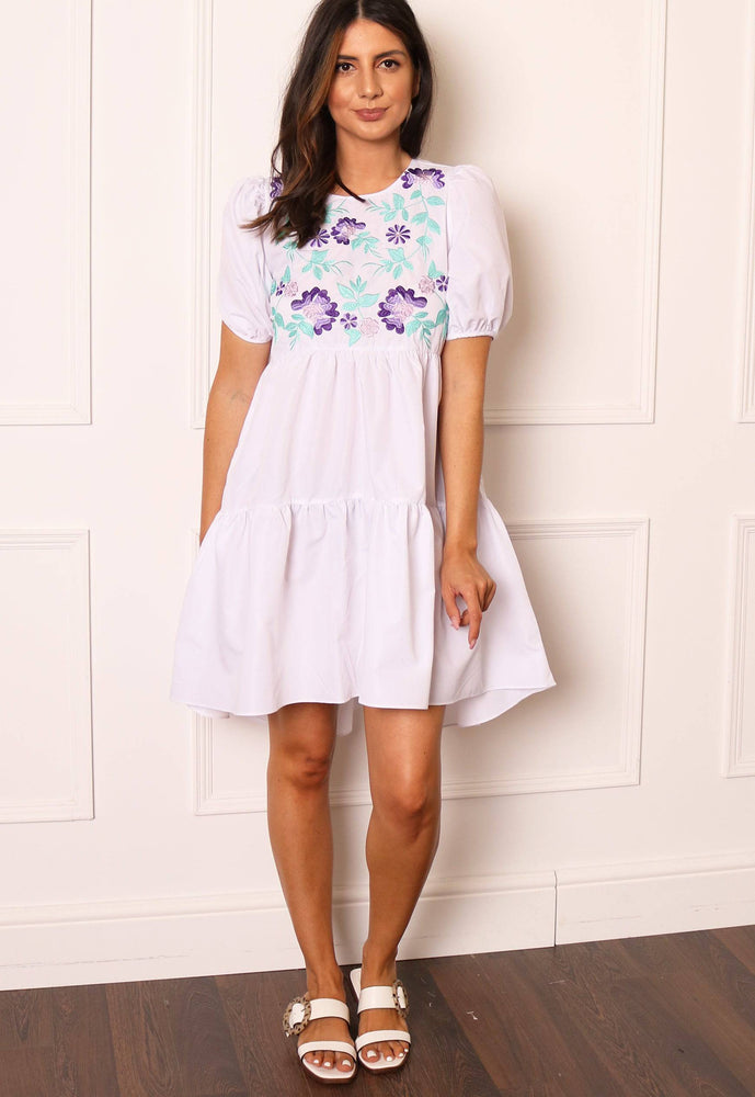 
                  
                    Voluminous Embroidered Tiered Dip Hem Mini Smock Dress with in White - One Nation Clothing
                  
                